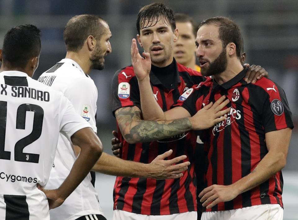 FILE - In this Nov. 11, 2018 file photo, AC Milan's Gonzalo Higuain, right, talks with Juventus' Giorgio Chiellini, during a Serie A soccer match between AC Milan and Juventus, at Milan's San Siro stadium.The Italian Super Cup is normally looked upon as little more than a friendly, the traditional curtain-raiser to a season. But this year it is being played against a backdrop of political outrage and protests. Italian politicians and human rights activists have objected to the game being played in Saudi Arabia, citing the assassination of Washington Post columnist Jamal Khashoggi at the Saudi Consulate in Istanbul, Turkey. (AP Photo/Luca Bruno)
