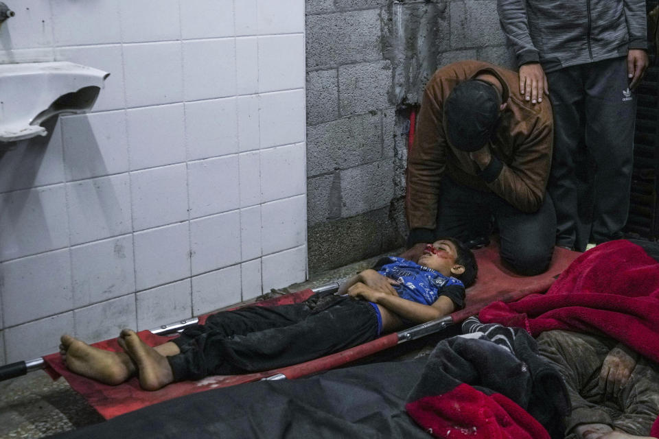 A man reacts next to the body of a boy killed in an Israeli bombardment of the Gaza Strip at al Aqsa Hospital in Deir al Balah, Gaza Strip, Tuesday, April 9, 2024. (AP Photo/Abdel Kareem Hana)