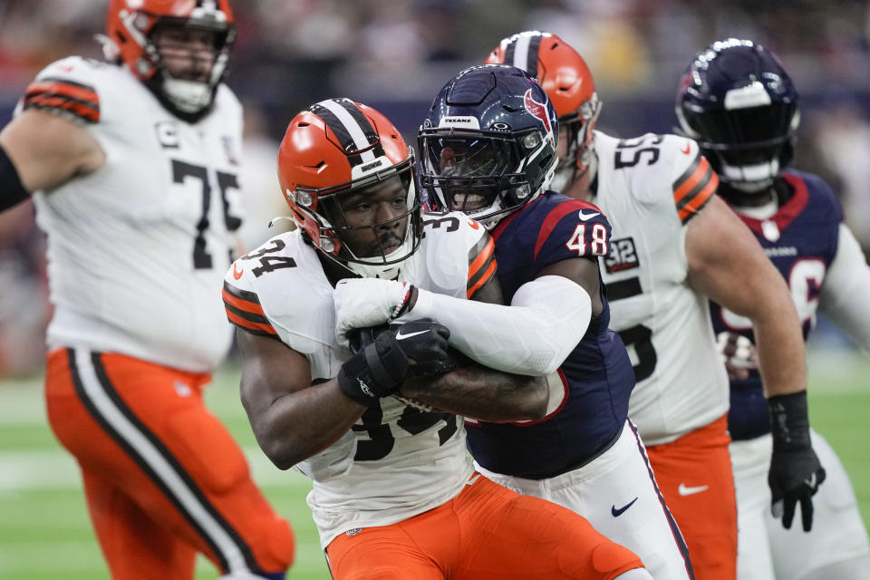 Houston Texans linebacker Christian Harris (48) tackles Cleveland Browns running back Jerome Ford (34) during the first half of an NFL football game Sunday, Dec. 24, 2023, in Houston. (AP Photo/David J. Phillip)