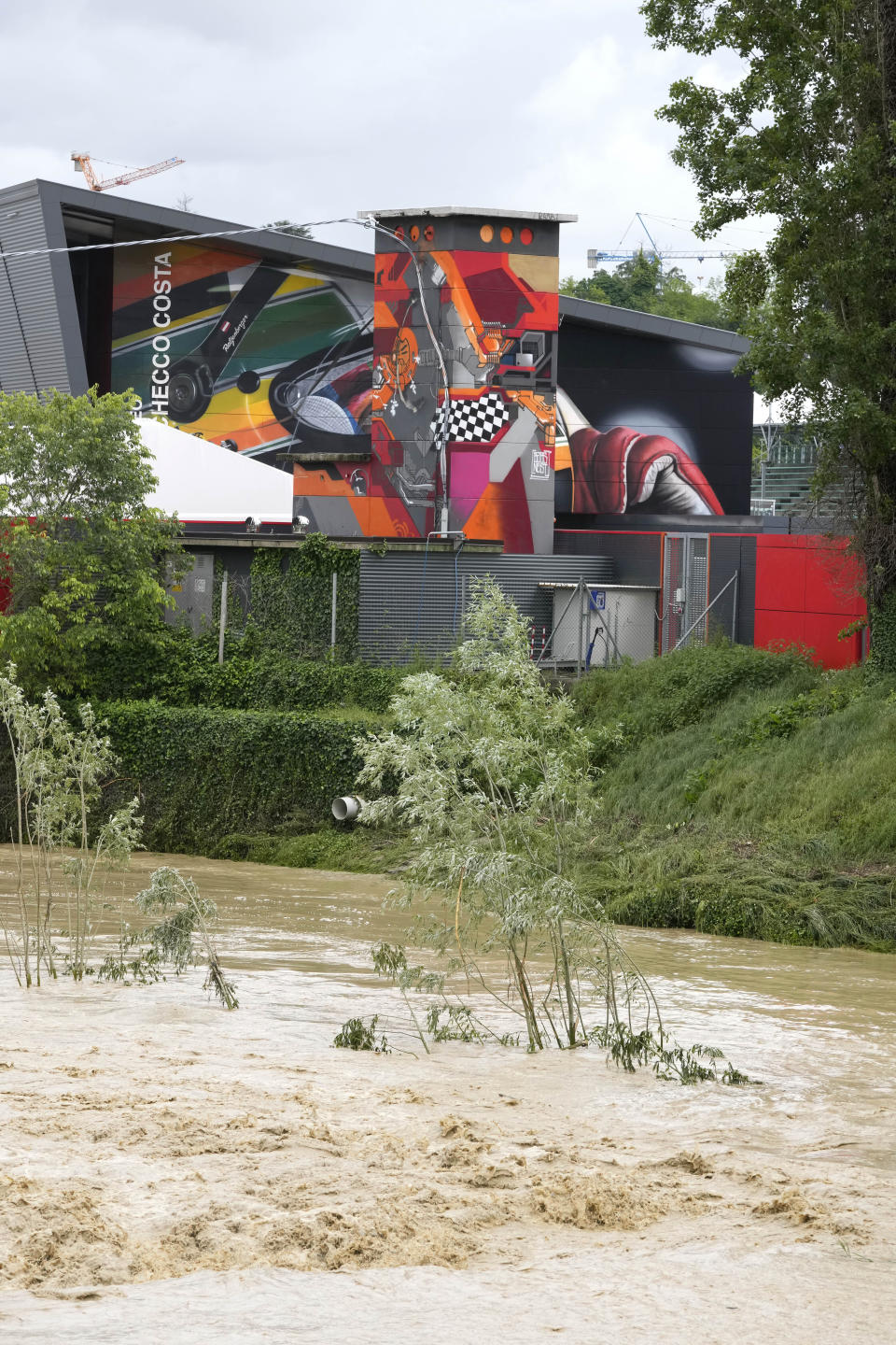 A view of the swollen Santerno River with behind the Enzo e Dino Ferrari circuit, in Imola, Italy, Wednesday, May 17, 2023. The weekend's Emilia-Romagna Grand Prix in Imola has been canceled because of deadly floods. Formula One said it made the decision for safety reasons and to avoid any extra burden on the emergency services. F1 personnel had earlier been told to stay away from the track after floods affected large parts of the Emilia-Romagna region. (AP Photo/Luca Bruno)