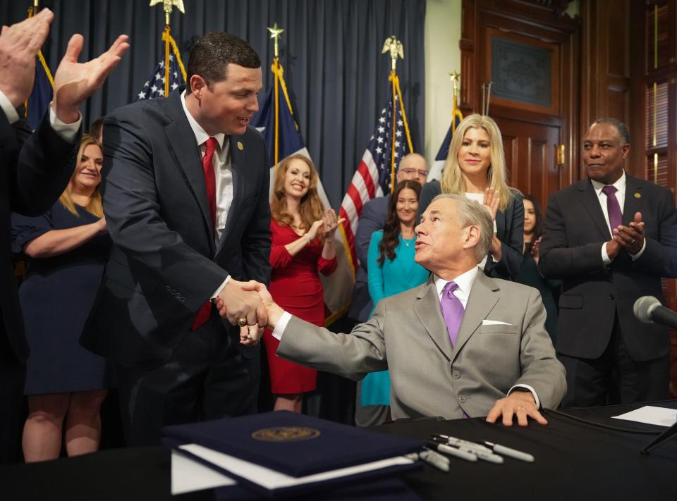 Gov. Greg Abbott, right, congratulates Rep. Jared Patterson, R-Frisco, after the governor signed into law HB 900, legislation that prohibits sexually explicit material in Texas public school libraries, at the Capitol on June 12.