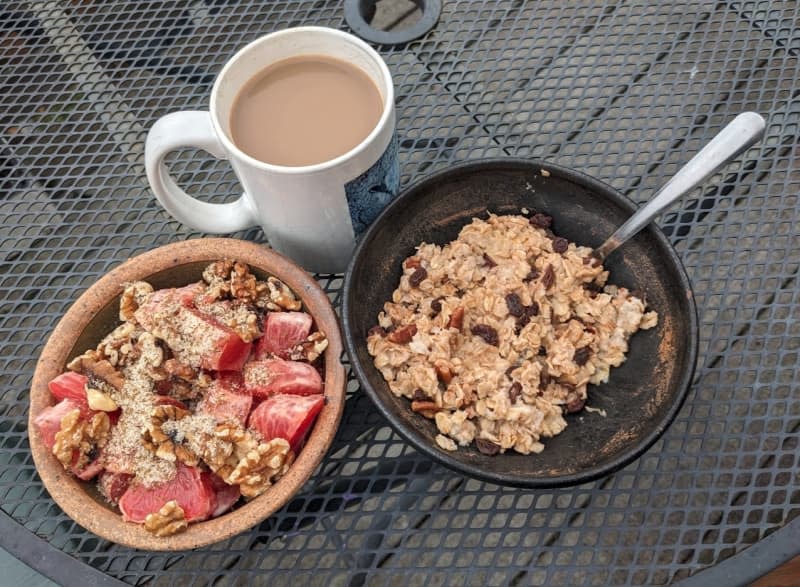 2 bowls of cereal on with fruit and a cup of coffee