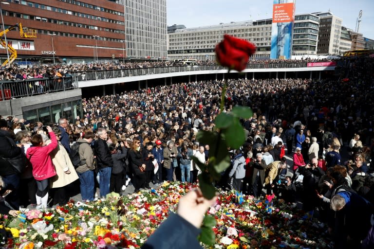 People attend a memorial ceremony at Sergels Torg plaza in Stockholm