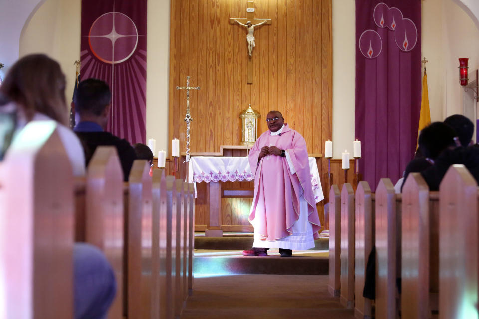 The Rev. Athanasius Abanulo celebrates Mass at Holy Family Catholic Church in Lanett, Ala., on Sunday, Dec. 12, 2021. Originally from Nigeria, Abanulo is one of numerous international clergy helping ease a U.S. priest shortage by serving in Catholic dioceses across the country. (AP Photo/Jessie Wardarski)