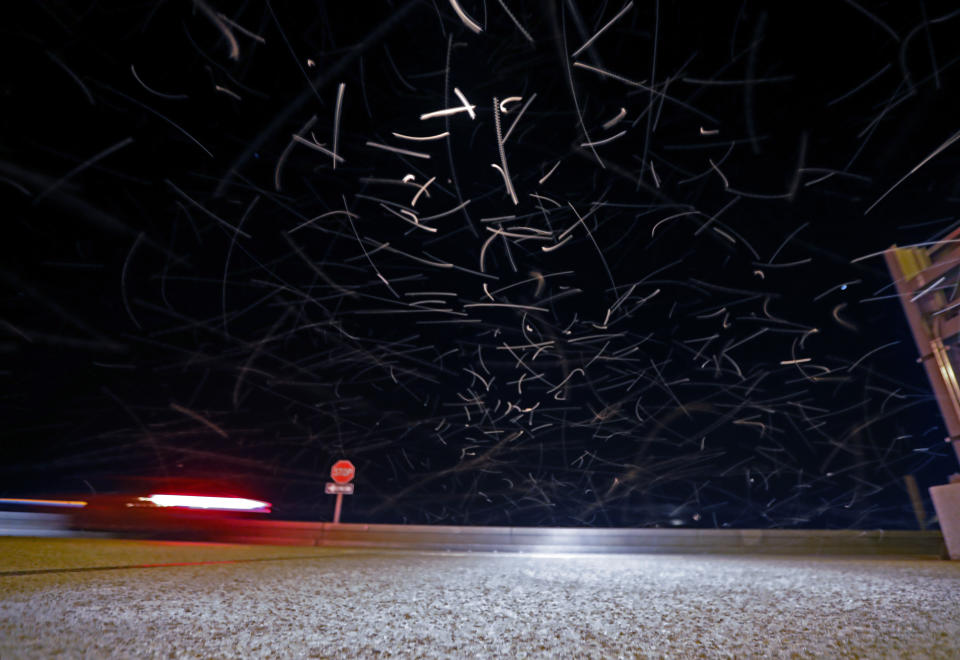 In this time exposure of 1/10 second, a swarm of blind mosquitoes, or aquatic midges, is seen as traffic drives on the Causeway Bridge, with dead ones on the pavement, over Lake Pontchartrain, in Jefferson Parish, outside New Orleans, Tuesday, June 18, 2019. Billions of mosquito lookalikes are showing up in the New Orleans area, blanketing car windshields, littering the ground with bodies and even scaring some folks. They're aquatic midges, also called "blind mosquitoes," but these flies don't bite. However, the Motorist Assistance Patrol on the 24-mile-long Lake Pontchartrain Causeway has been stocking extra water to slosh down windshields. (AP Photo/Gerald Herbert)