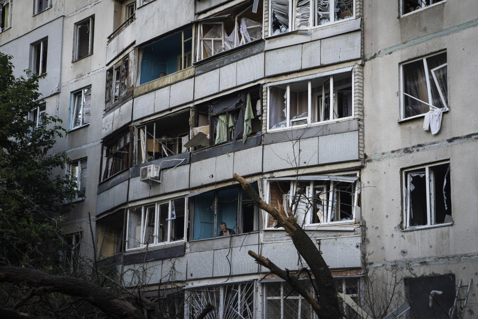 A man looks out of a balcony of his house which was damaged after Russian bombardment at a residential neighborhood in Kharkiv, Ukraine, on Thursday, July 7, 2022. (AP Photo/Evgeniy Maloletka)