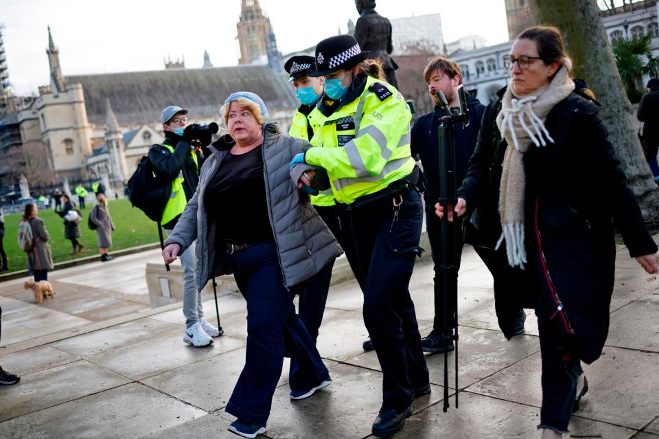 Unmasked demonstrators were escorted away by policeAFP via Getty Images