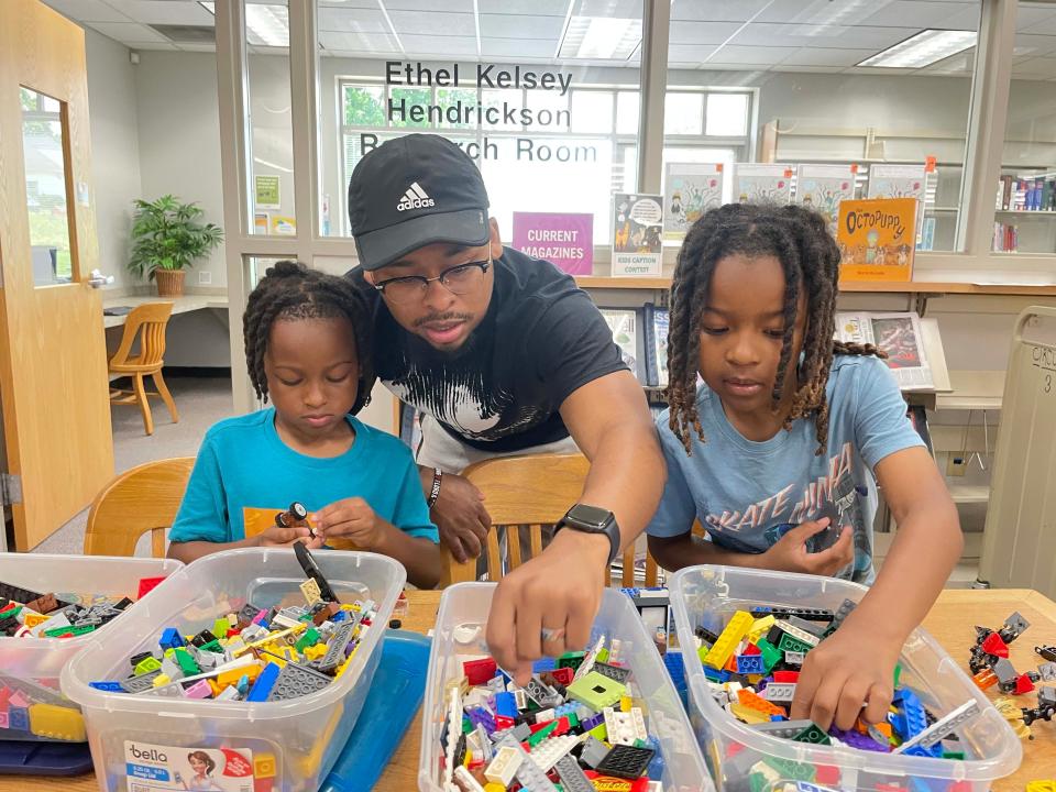 Dad John Johnson of Hardin Valley gets in on the build with his two sons, Ayvre (left) and Ayce, at the monthly LEGO Club at Karns Branch Library Saturday, May 21, 2022.