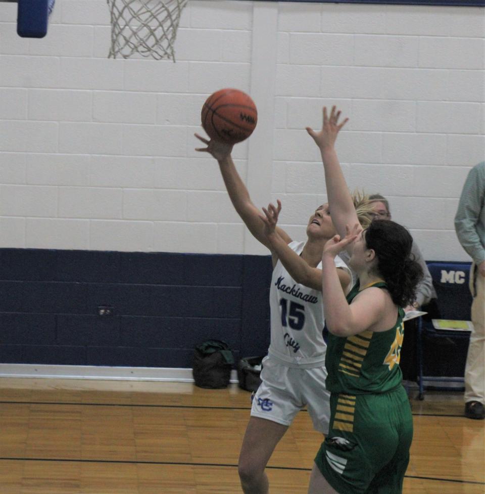 Mackinaw City senior Marlie Postula (15) goes in for a layup while Engadine's Elisa Carfora (45) attempts to make a block during the second quarter on Wednesday.