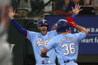 Texas Rangers' Jonah Heim, left, reacts after Wyatt Langford (36) scored on an inside-the-park home run against the Cincinnati Reds in the first inning of a baseball game Sunday, April 28, 2024, in Arlington, Texas. (AP Photo/Richard W. Rodriguez)