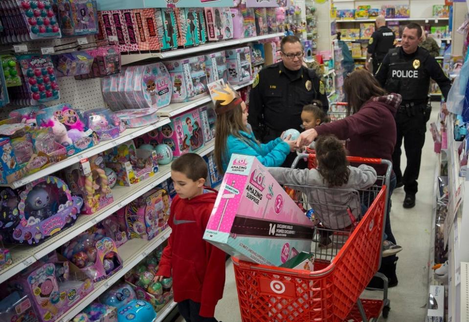 Police escort a family on a Christmas shopping trip to Target during the annual Heroes and Helpers event in this 2019 file photo.