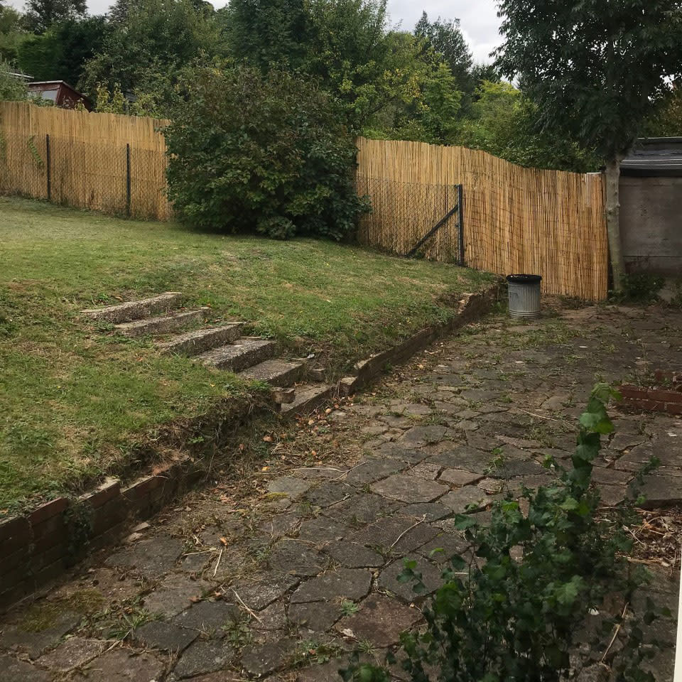 Before shot of a sloped garden and terrace at the bottom