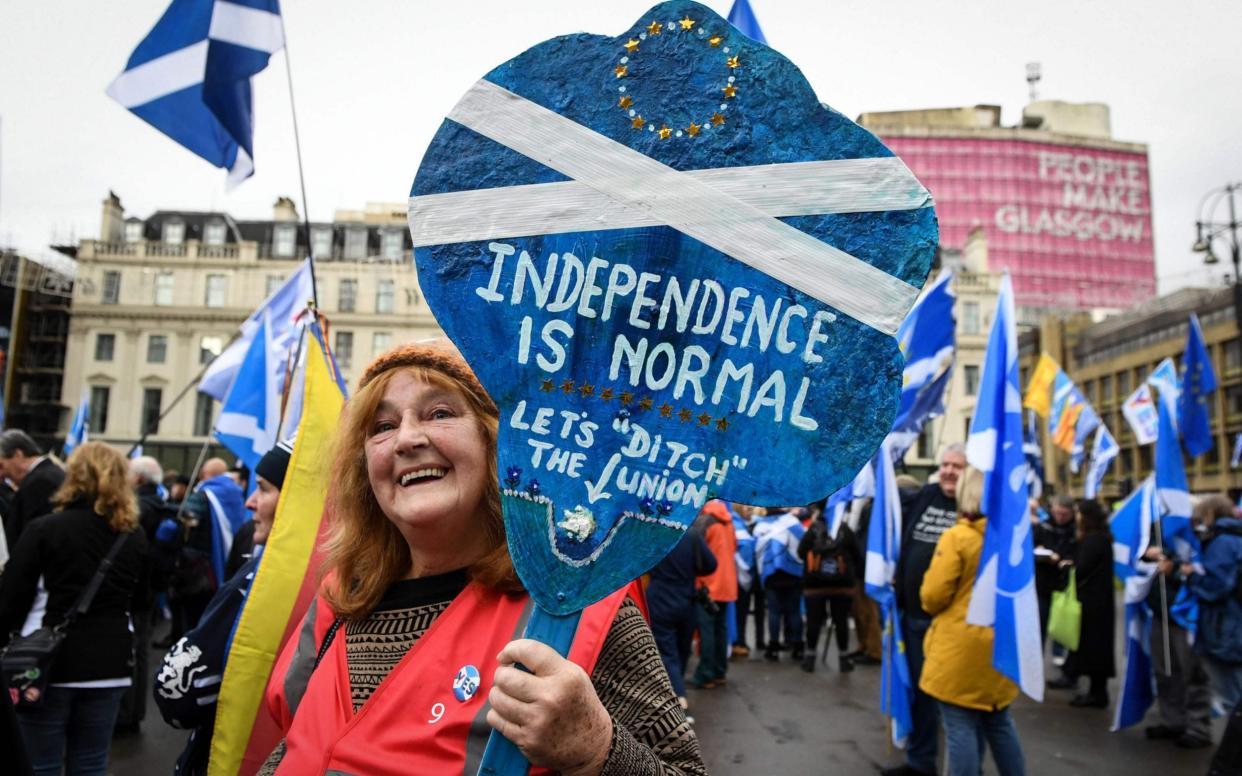 A pro-independence supporter displays a placard at a rally calling for Scottish independence in Glasgow - AFP