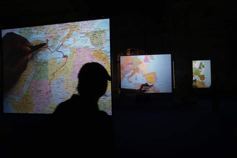 CORRECTS SPELLING OF FIRST NAME TO BOUCHRA INSTEAD OF BOUKRA - A visitor looks the installation "The mapping Journey," by artist Bouchra Khalili at the 60th Biennale of Arts exhibition in Venice, Italy, Tuesday, April 16, 2024. The Venice Biennale contemporary art exhibition opens Saturday for its six-month run through Nov. 26. (AP Photo/Luca Bruno)