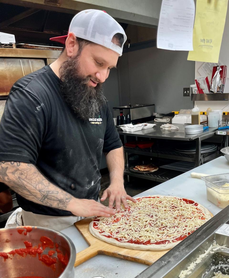 Enrico Aguila, also known as Uncle Rico, prepares one of his New York-style pies, recently named third best in Florida.