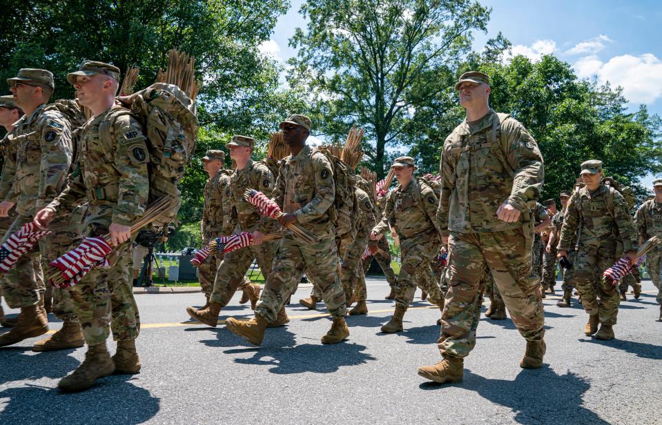 Members of the 3rd United States Infantry Regiment, also known as The Old Guard, place flags in front of each headstone as part of the "Flags In" ceremony at Arlington National Cemetery in Arlington, Va. on Thursday, May 27, 2021. Since 1948, The Old Guard has placed flags at each headstone in honor of Memorial Day.