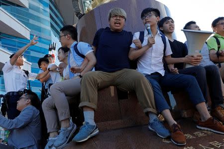 Pro-democracy activist Joshua Wong (4th R) chants slogans in front of the Golden Bauhinia sculpture during a protest to demand full democracy ahead of the 20th anniversary of the handover from Britain to China, in Hong Kong, China June 28, 2017. REUTERS/Tyrone Siu