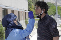 Salt Lake County Health Department public health nurse Lee Cherie Booth performs a coronavirus test outside the Salt Lake County Health Department Friday, July 10, 2020, in Salt Lake City. Utah has reported more than 28,000 confirmed cases of COVID-19. Case counts have more than doubled since mid-May after state leaders allowed some businesses to reopen. (AP Photo/Rick Bowmer)