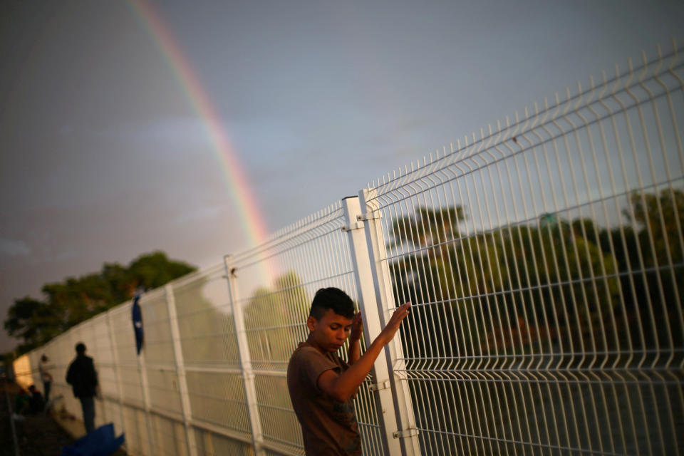 <p>A Central American migrant, part of a caravan trying to reach the U.S., waits to open the gate on the bridge that connects Mexico and Guatemala in Ciudad Hidalgo, Mexico, Oct. 21, 2018. (Photo: Edgard Garrido/Reuters) </p>