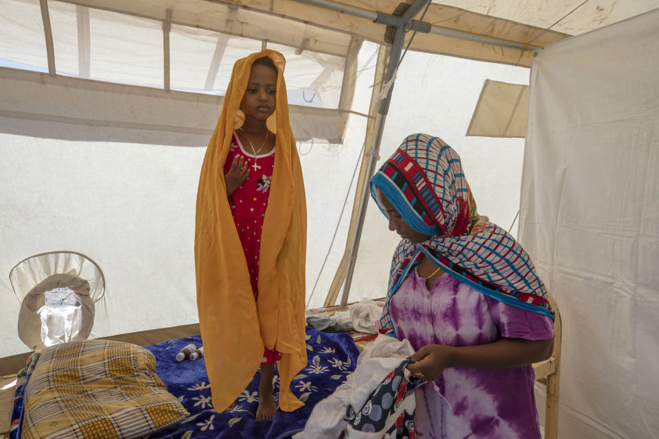 A Tigrayan mother cares for her daughter suffering from diarrhea and a high grade fever at a clinic run by MSF (Doctors Without Borders), in Hamdeyat near the Sudan-Ethiopia border, eastern Sudan, Tuesday, Dec. 15, 2020. (AP Photo/Nariman El-Mofty)