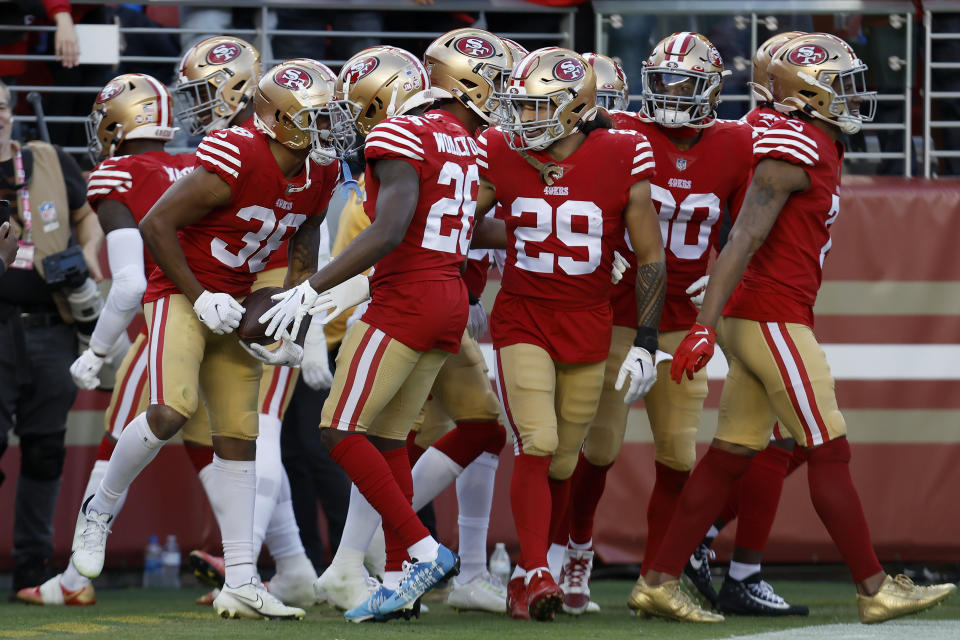 San Francisco 49ers cornerback Deommodore Lenoir, foreground left, celebrates with teammates after intercepting a pass during the second half of an NFL football game against the Miami Dolphins in Santa Clara, Calif., Sunday, Dec. 4, 2022. (AP Photo/Jed Jacobsohn)