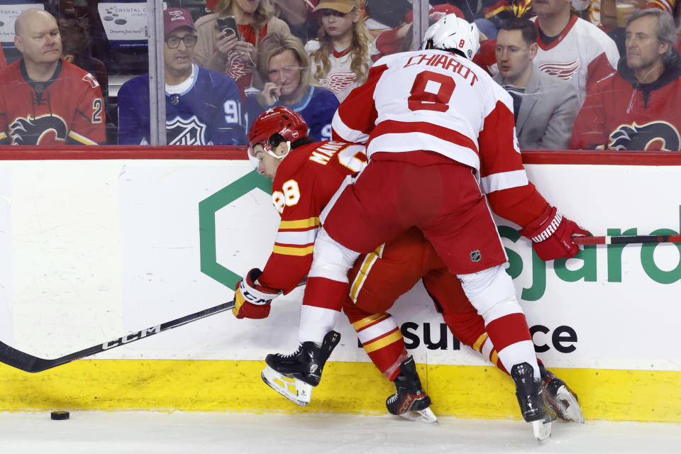 Calgary Flames' Andrew Mangiapane is knocked off the puck by Detroit Red Wings' Ben Chiarot, right, during the first period of an NHL hockey game in Calgary, Alberta, Saturday, Feb. 17, 2024. (Larry MacDougal/The Canadian Press via AP)