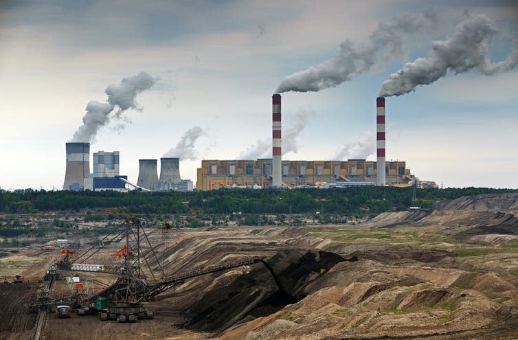 A coal-fired power station belching steam and smoke.