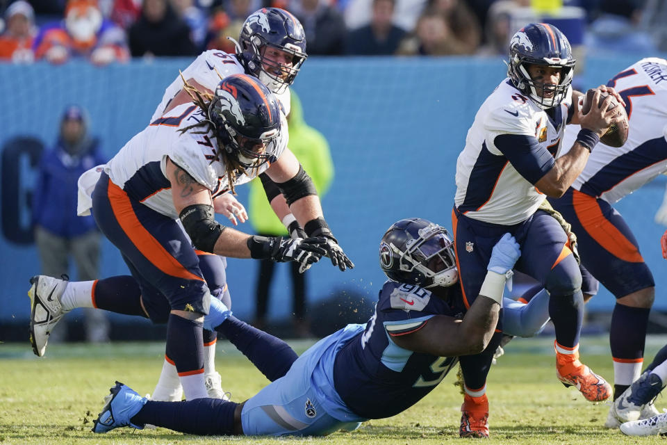 Tennessee Titans defensive tackle Naquan Jones (90) tackles Denver Broncos quarterback Russell Wilson (3) during the second half of an NFL football game, Sunday, Nov. 13, 2022, in Nashville, Tenn. (AP Photo/Mark Humphrey)