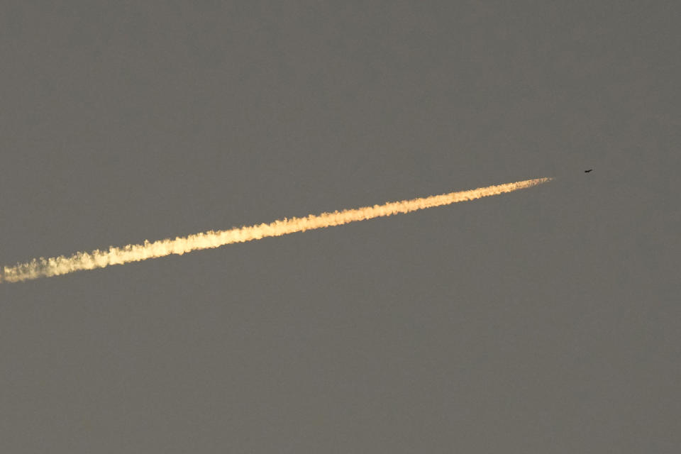 An Israel war plane flies over Lebanon as the sun sets over Tair Harfa village, a Lebanese border village with Israel, south Lebanon, Friday, Oct. 20, 2023. (AP Photo/Hassan Ammar)