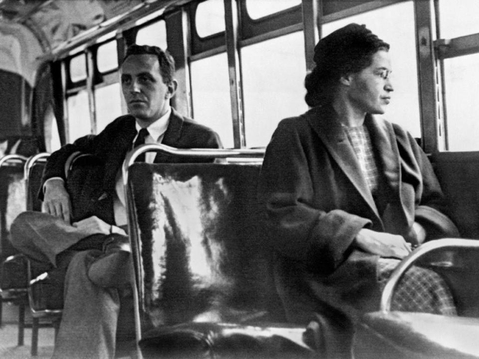 Rosa Parks sits at the front of a bus in 1955