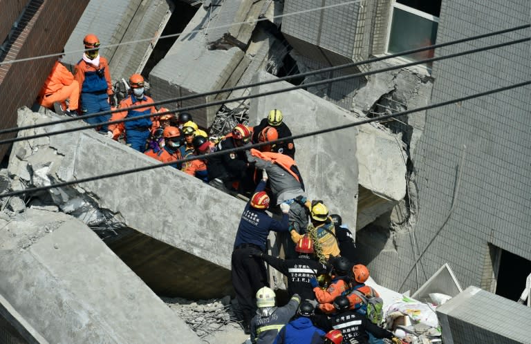 Rescue workers transport a survivor rescued from the rubble at the Wei-kuan apartment complex on February 7, 2016, the second day of rescue operations following a 6.4 magnitude earthquake that struck Tainan