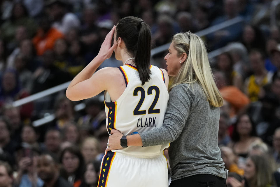 Indiana Fever guard Caitlin Clark (22) is greeted by coach Christie Sides after a foul during the first half of the team's WNBA basketball game against the Los Angeles Sparks in Los Angeles, Friday, May 24, 2024. (AP Photo/Ashley Landis)