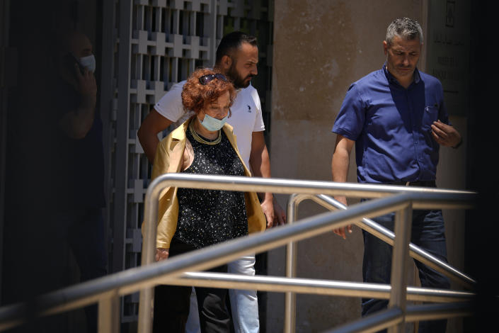 Lebanese Judge Ghada Aoun, left, leaves the Central Bank following a raid to pursue embattled Central Bank Governor Riad Salameh on corruption charges in Beirut, Lebanon, Tuesday, July 19, 2022. (AP Photo/Bilal Hussein)