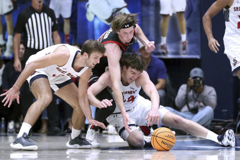 St. Mary’s Alex Ducas (44) and Augustas Marciulionis vie for a loose ball against Utah’s Branden Carlson during the first half of an NCAA college basketball game in Moraga, Calif., on Monday, Nov. 27, 2023. | Scott Strazzante/San Francisco Chronicle via AP