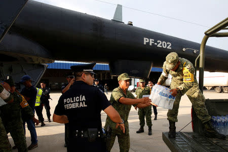 Federal police officers transport donated water for earthquake victims after an earthquake that struck off the southern coast of Mexico late on Thursday, in Union Hidalgo, Mexico, September 9, 2017. REUTERS/Carlos Jasso