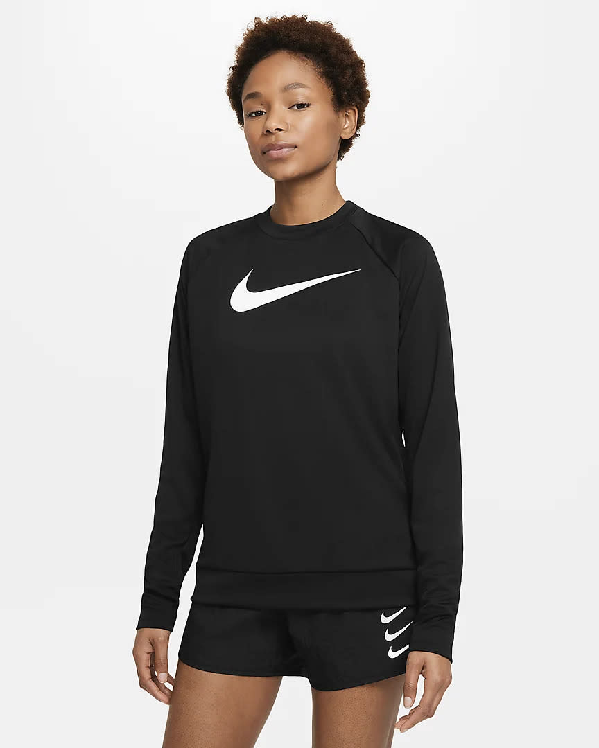 Woman wearing black long sleeve with Nike Swoosh logo on front.