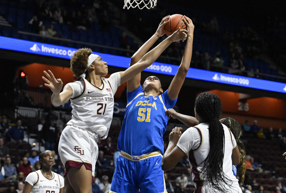 UCLA center Lauren Betts (51) grabs a rebound over Florida State forward Makayla Timpson (21) in the second half of an NCAA college basketball game, Sunday, Dec. 10, 2023, in Uncasville, Conn. (AP Photo/Jessica Hill)