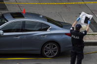<p>Police are photographed investigating a car with a bullet hole within the scene of a mass shooting in Toronto on July 23, 2018. (Photo: Christopher Katsarov/The Canadian Press via AP) </p>