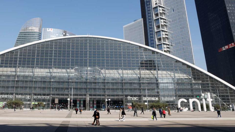 People walk by the CNIT shopping mall on the Parvis de la Defense in Paris' business district of La Defense, outside Paris, on March 23, 2021. (Photo by Ludovic MARIN / AFP)