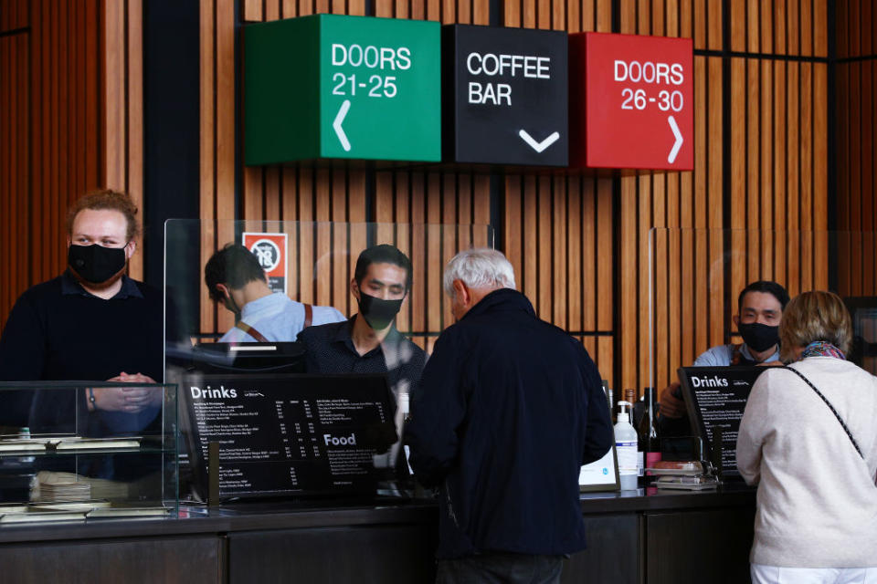 Staff are seen wearing face masks as they serve guests on arrival for the Don Burrows: A Celebration of Life Through Jazz show in the Joan Sutherland Theatre at the Sydney Opera House.