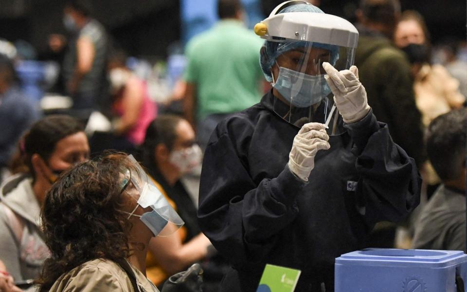 A health worker prepares a dose of the Pfizer-BioNTech vaccine against COVID-19 to inoculate a woman in Bogota, on June 16, 2021. - Colombia has officially recorded more than 90,000 Covid-19 deaths. - AFP