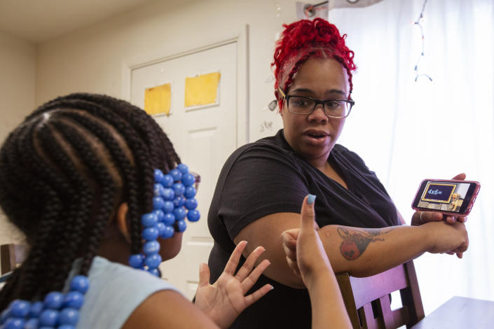 Ke'Arrah Jessie, 9, counts on her fingers while being quizzed on multiplication by her mom, Ashley Martin, in their kitchen in Niagara Falls, N.Y., on Monday, April 3, 2023. When Ke’Arrah was assigned to a new elementary school for this year, her mother re-enrolled her in third grade, because she had difficulty following along with online learning during the COVID-19 shutdown. (AP Photo/Lauren Petracca)