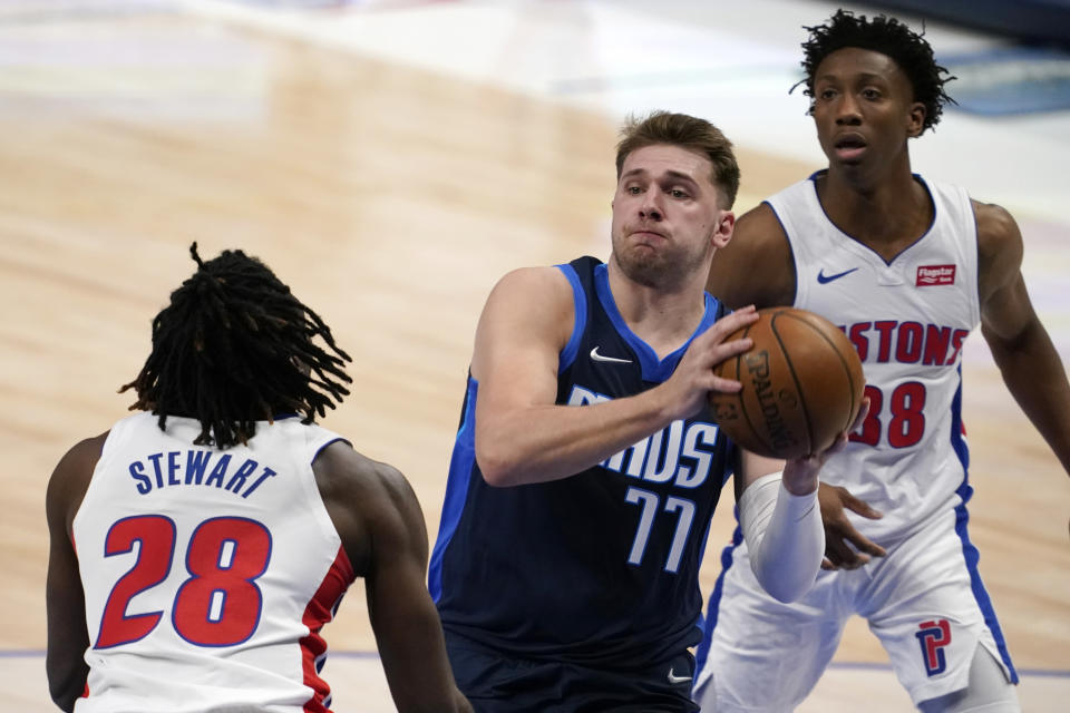 Detroit Pistons' Isaiah Stewart (28) and Saben Lee, rear, defend as Dallas Mavericks guard Luka Doncic (77) drives to the basket during the first half of an NBA basketball game in Dallas, Wednesday, April 21, 2021. (AP Photo/Tony Gutierrez)
