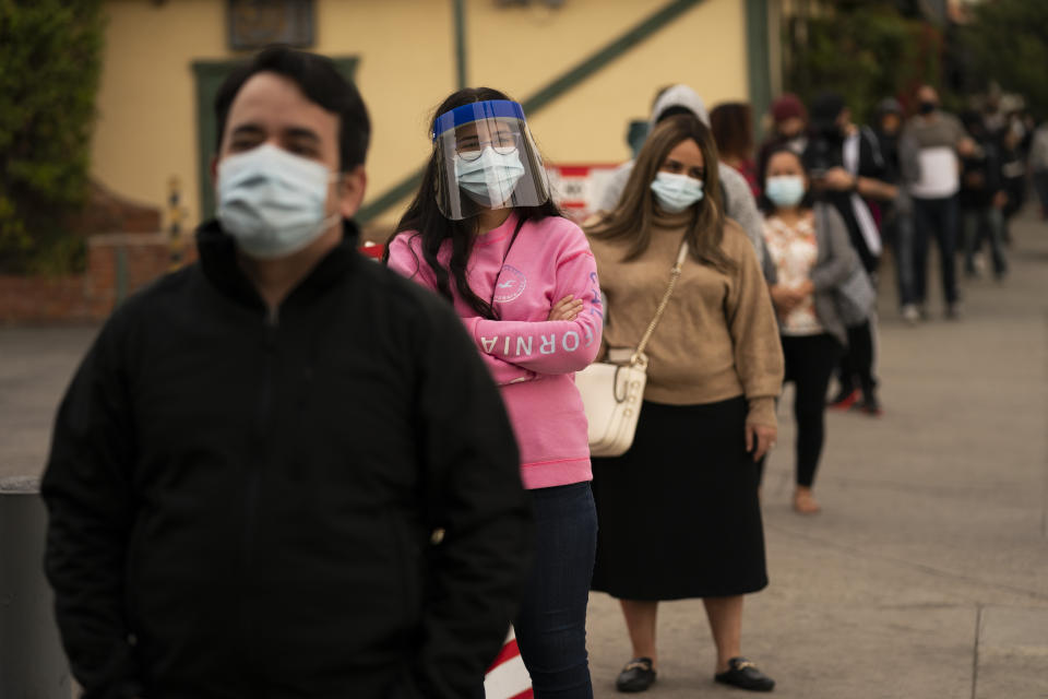 People wait in line for COVID-19 testing at a testing site operated by CORE in Los Angeles, Monday, Dec. 7, 2020. The vast region of Southern California went into a lockdown Monday in an effort to curb spiraling coronavirus infections and hospitalizations. (AP Photo/Jae C. Hong)