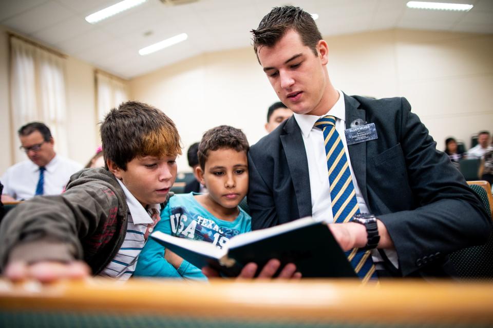 Elder Tanner McKee, a missionary for The Church of Jesus Christ of Latter-day Saints, helps Lucas and Murilo read the hymnbook during sacrament meeting at the local chapel in Paranaguá, Brazil, on Sunday, June 2, 2019. | Spenser Heaps, Spenser Heaps, Deseret News, Deseret News