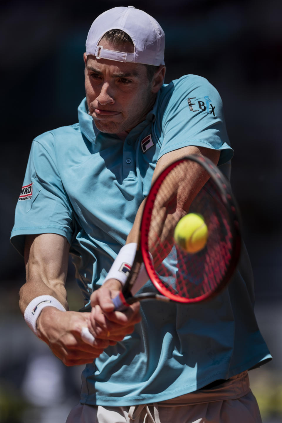United States' John Isner returns the ball to Austria's Dominic Thiem during their match at the Mutua Madrid Open tennis tournament in Madrid, Spain, Friday, May 7, 2021. (AP Photo/Bernat Armangue)
