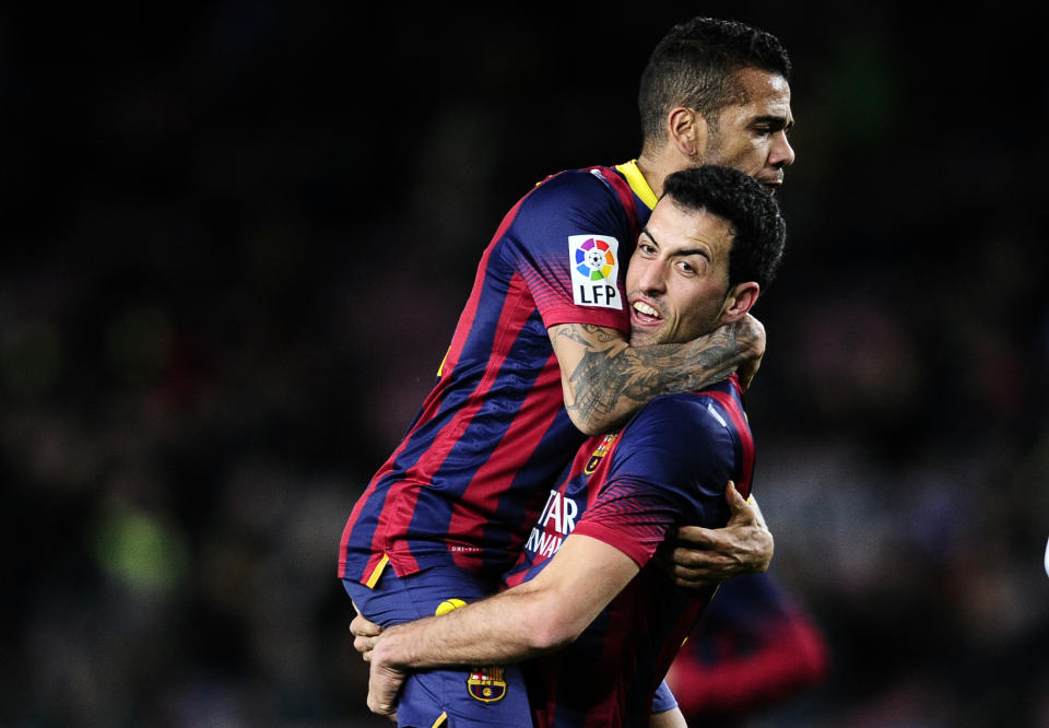 FC Barcelona's Sergio Busquets, right, huges Daniel Alves, from Brazil, left after scoring against Real Sociedad during a Copa del Rey soccer match at the Camp Nou stadium in Barcelona, Spain, Wednesday, Feb. 5, 2014. (AP Photo/Manu Fernandez)