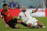Belgium's Thorgan Hazard, left, and Morocco's Sofyan Amrabat challenge for the ball during the World Cup group F soccer match between Belgium and Morocco, at the Al Thumama Stadium in Doha, Qatar, Sunday, Nov. 27, 2022. (AP Photo/Christophe Ena)