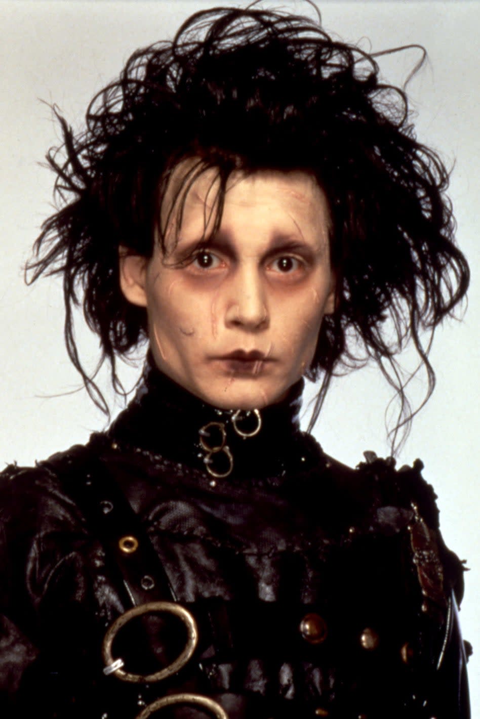 Edward Scissorhands in character with signature scissor hands and textured black outfit