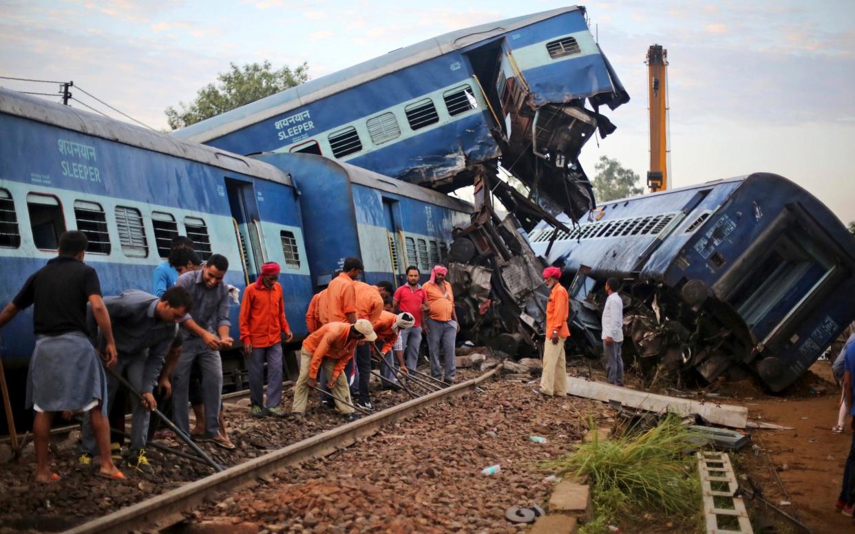 Workers repair the track near the upturned coaches of the Kalinga-Utkal Express - AP